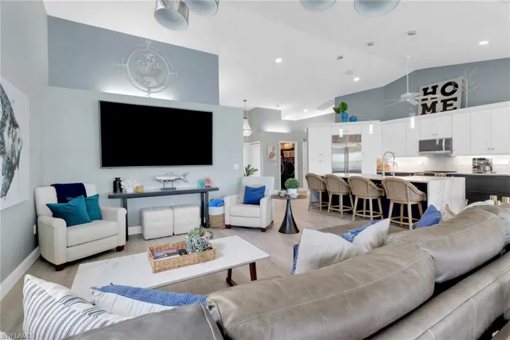 Living room with light wood-type flooring and high vaulted ceiling