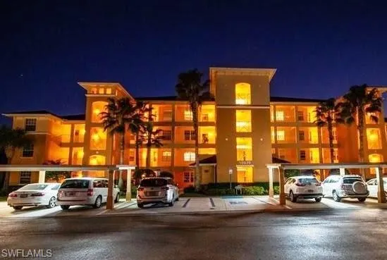 View of apartment building / complex with uncovered parking