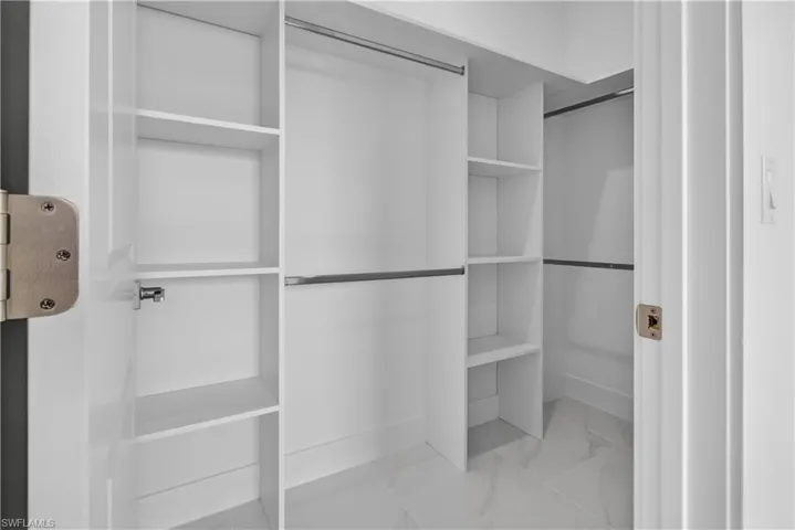 White closet system with multiple shelving units and hanging rods