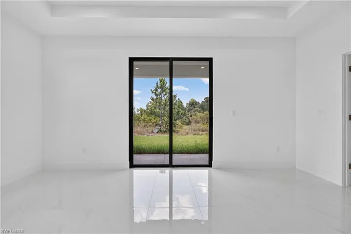 Bright interior space featuring a black-framed sliding glass door opening to a private outdoor area