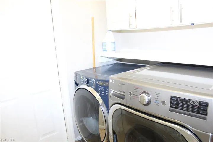 Clothes washing area featuring cabinet space and washer and dryer