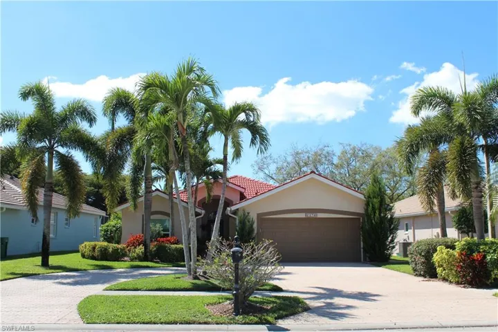 View of front of home featuring a front lawn, decorative driveway, an attached garage, and stucco siding