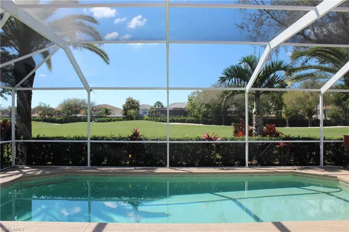 Pool with glass enclosure, a patio, and golf course view