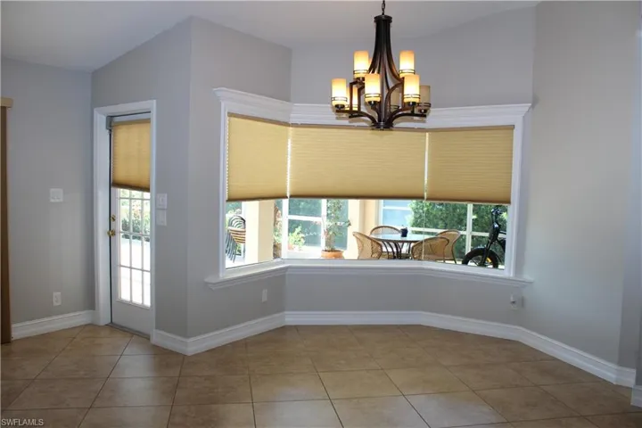 Unfurnished dining area featuring a chandelier, healthy amount of natural light, and tile patterned flooring