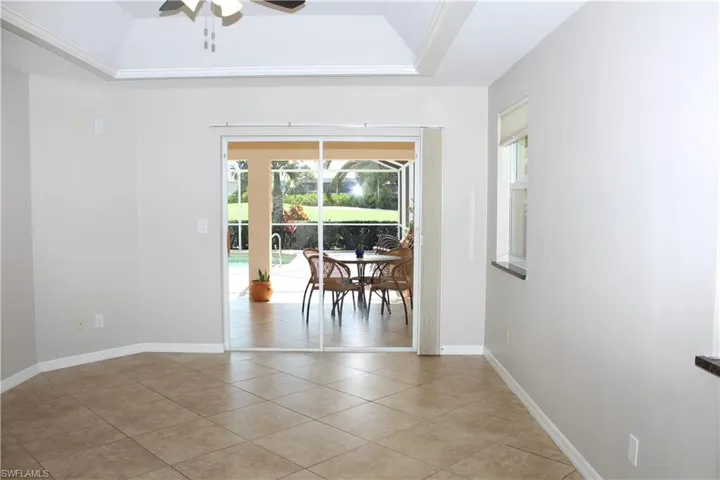 Master Bedroom featuring a tray ceiling, ceiling fan, light tile patterned floors, and a sunroom