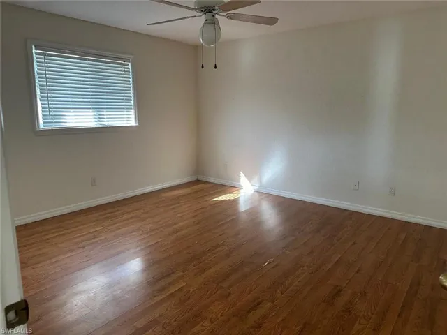 Unfurnished room featuring dark wood finished floors and a ceiling fan