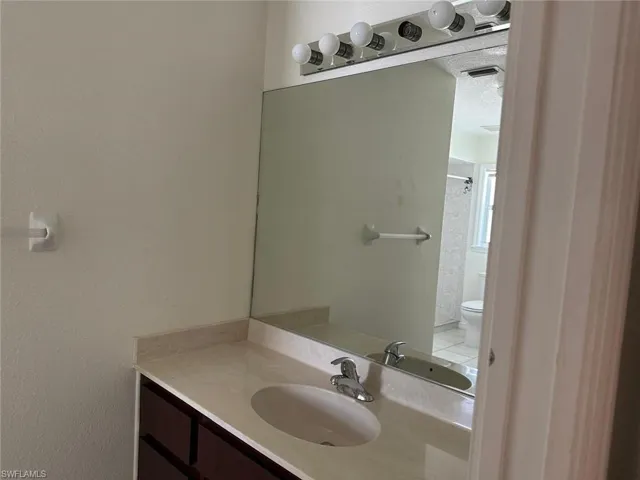 Bathroom with vanity, a shower, and a textured ceiling