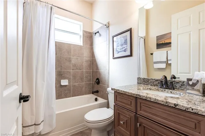 Full bathroom with shower/tub combo, vanity, and toilet