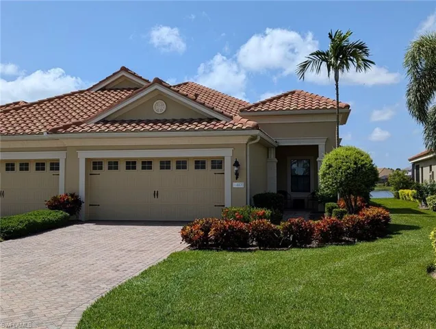 Mediterranean / spanish-style home featuring a garage and a front lawn