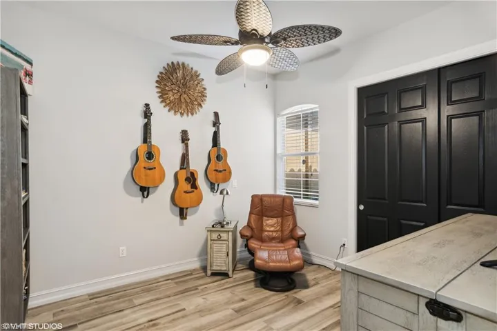 Sitting room with light wood-type flooring and ceiling fan