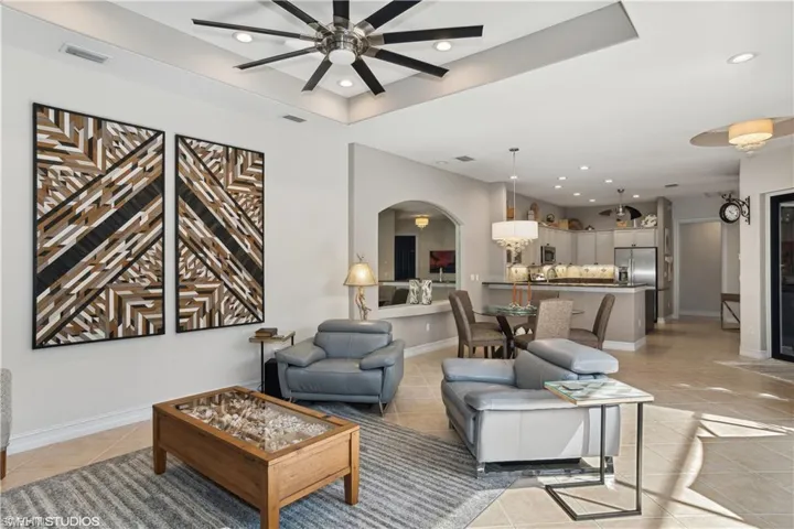 Living room with ceiling fan and light tile floors