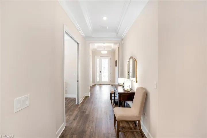 Hallway with crown molding, dark wood-style floors, and french doors