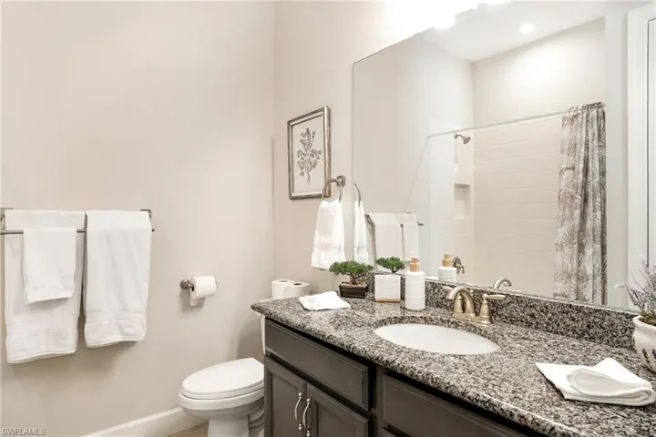 Full bath featuring vanity and curtained shower
