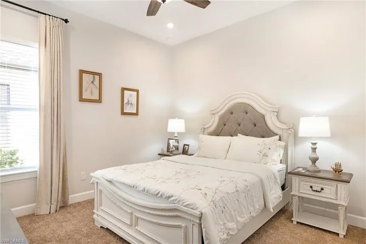 Bedroom with light carpet, ceiling fan, and recessed lighting