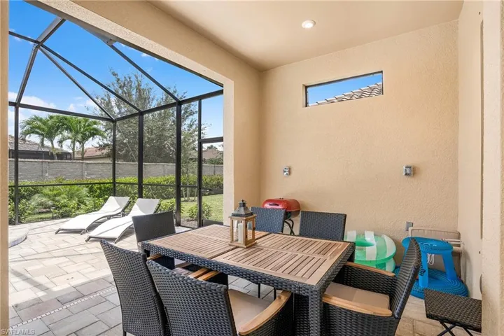 View of patio featuring a sunroom, outdoor dining area, and a lanai