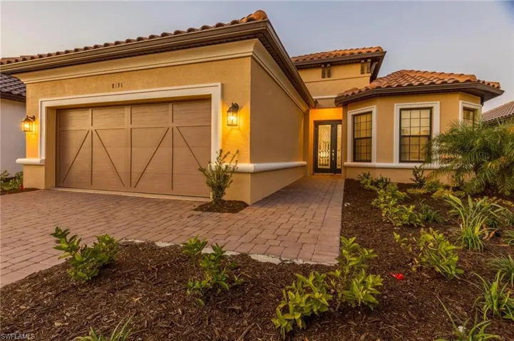 Mediterranean / spanish house featuring stucco siding, decorative driveway, an attached garage, and a tiled roof