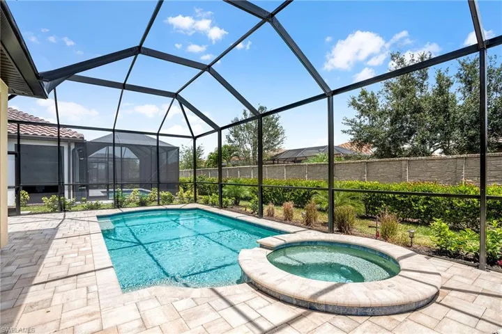 View of pool with a sunroom, a pool with connected hot tub, a lanai, and a patio area