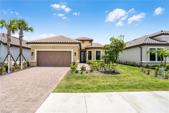 Mediterranean / spanish home with stucco siding, a front yard, decorative driveway, a garage, and a tiled roof