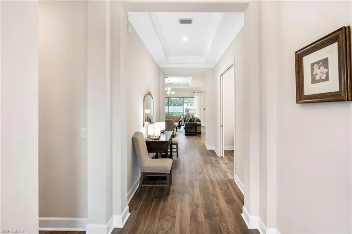 Corridor with dark wood-style floors and crown molding