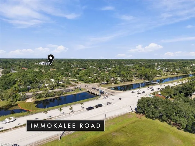 Aerial perspective featuring Immokalee Road frontage, bordering canal systems, and established canopy vegetation