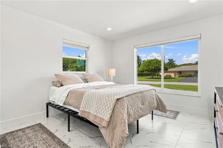 Bright room featuring white tile flooring, large windows, and recessed lighting