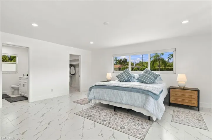Interior space featuring large-format stone-patterned tile flooring, recessed ceiling lighting, a wide horizontal window, and a built-in walk-in closet