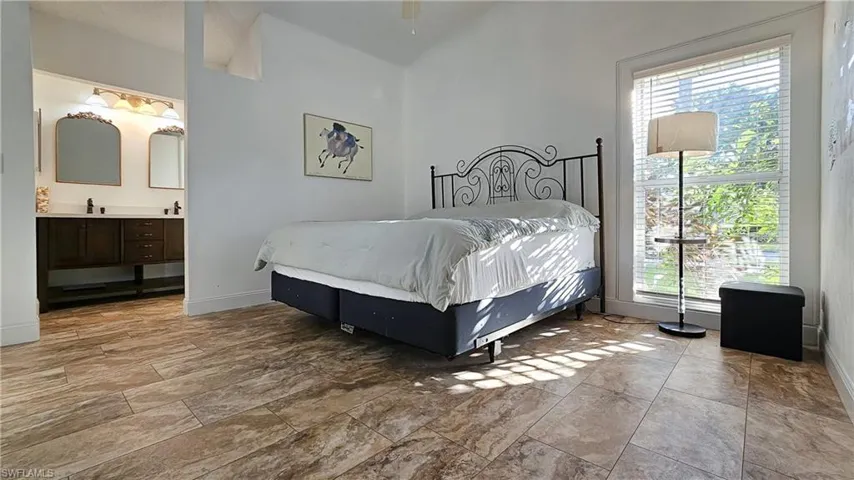 Bedroom featuring baseboards and ensuite bathroom