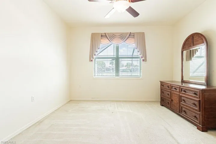 Empty room with light carpet and ceiling fan