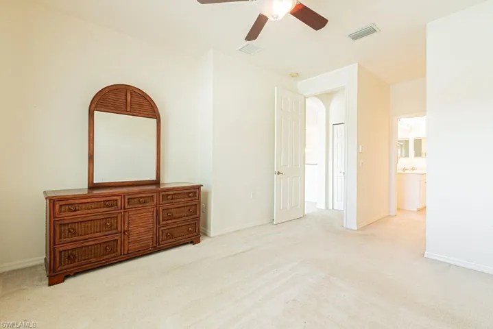 Unfurnished bedroom with light colored carpet and ceiling fan