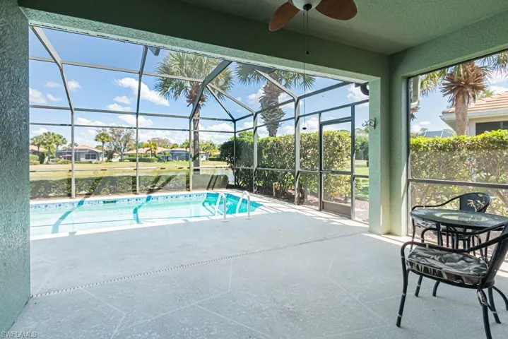 Outdoor pool featuring glass enclosure, a patio, and a sunroom