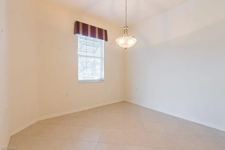 Spare room with baseboards and light tile patterned floors