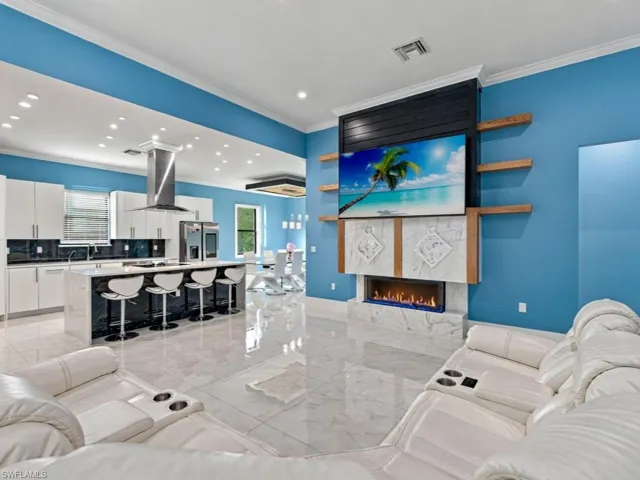 Open-concept living space featuring high-gloss tile flooring, recessed lighting, and a linear fireplace with stone-surround facade