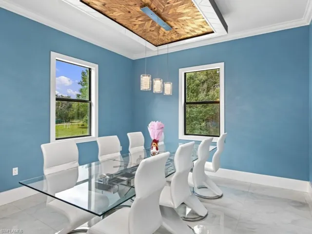 Tray ceiling with herringbone wood inlay, pendant lighting, large-format tile flooring, and dual double-pane windows