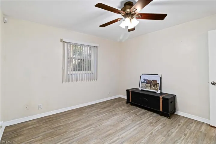 Empty room with ceiling fan and light hardwood / wood-style floors