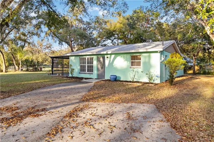 View of front of property featuring a sunroom and a front lawn