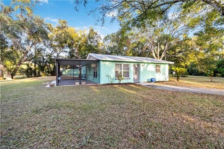 View of front facade with a front yard and a sunroom