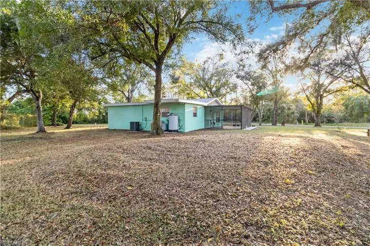 View of yard with cooling unit and a sunroom