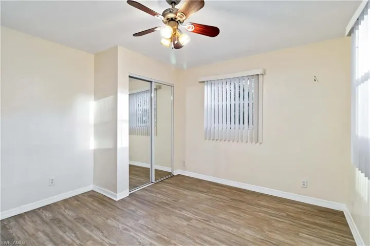 Unfurnished bedroom featuring hardwood / wood-style flooring, ceiling fan, and a closet