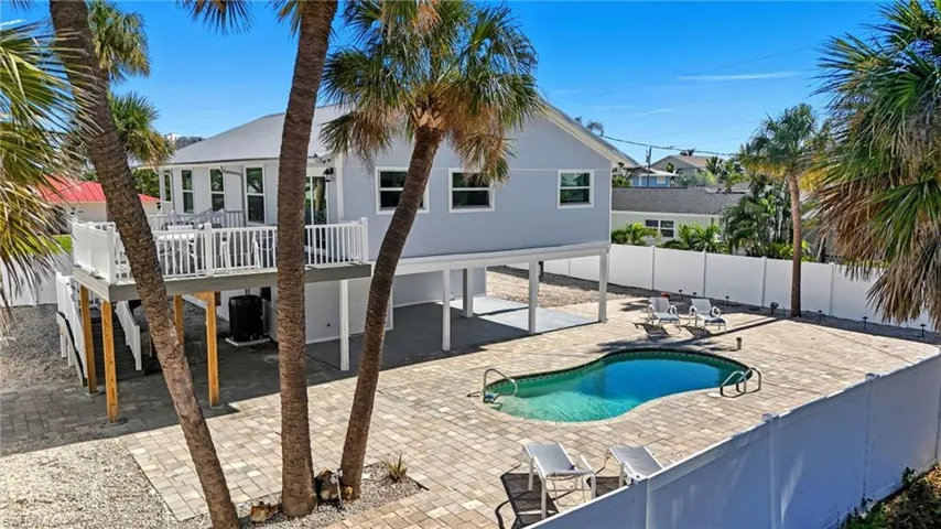 View of pool featuring a fenced backyard, a patio area, and stairs - Virtually Edited Image