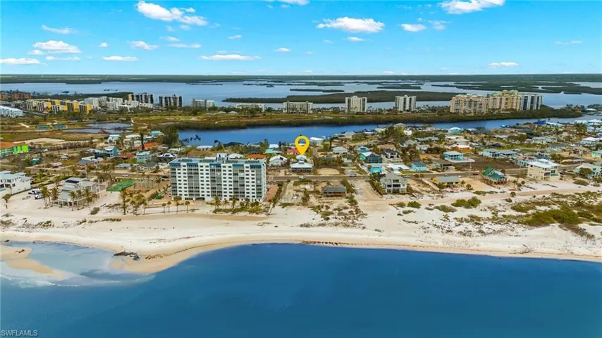 Aerial view featuring a water view and a view of the beach virtually enhanced image