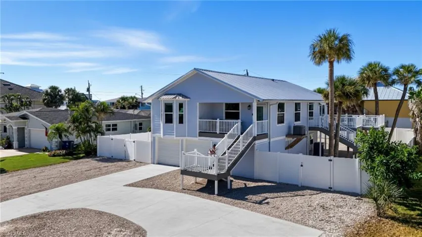 Ranch-style house with a gate, stairs, concrete driveway, and a garage - Virtually Edited Image