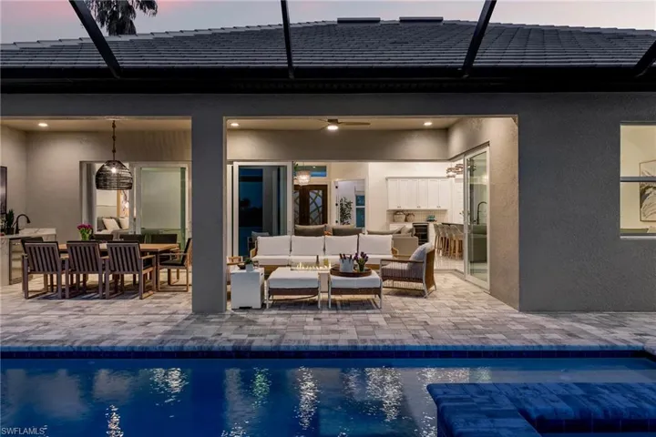 Outdoor pool featuring an outdoor hangout area, ceiling fan, a patio, and glass enclosure