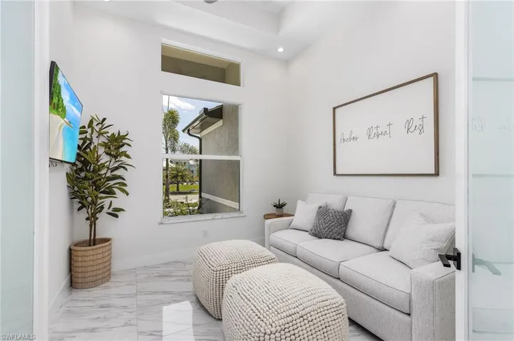 Living room with recessed lighting, baseboards, and marble finish flooring