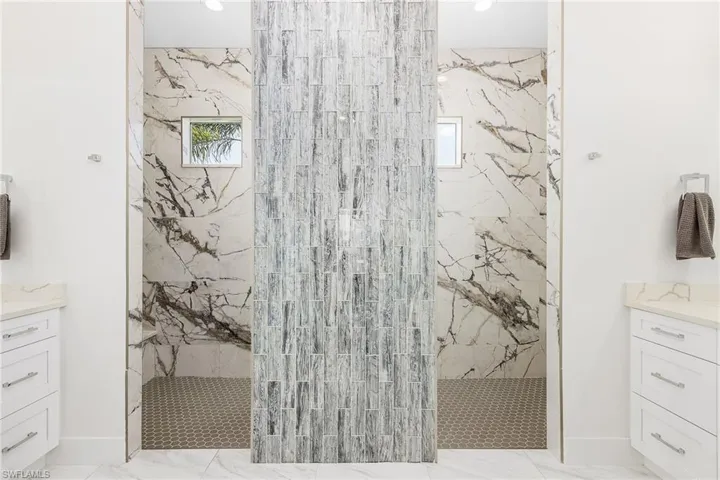 Bathroom with vanity, a marble finish shower, plenty of natural light, and recessed lighting