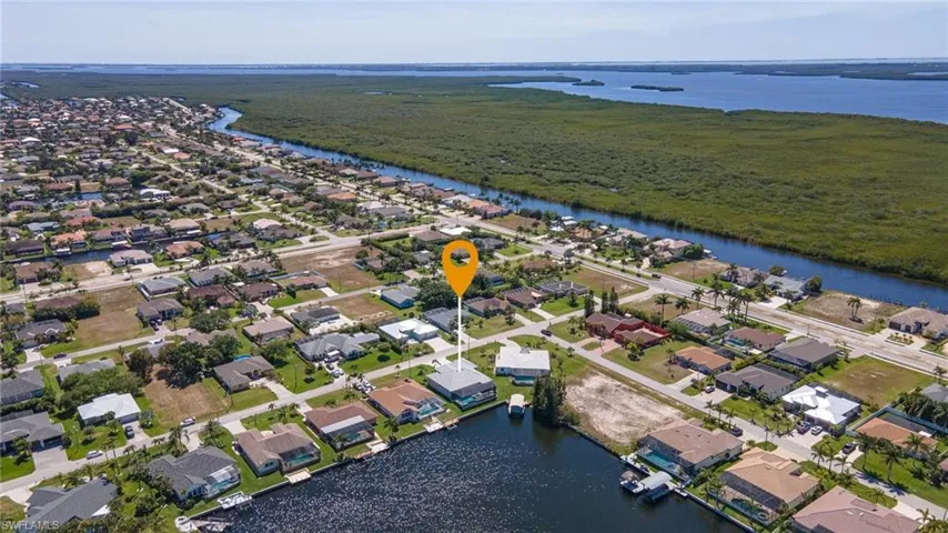 Aerial view of property's location featuring a nearby body of water and nearby suburban area