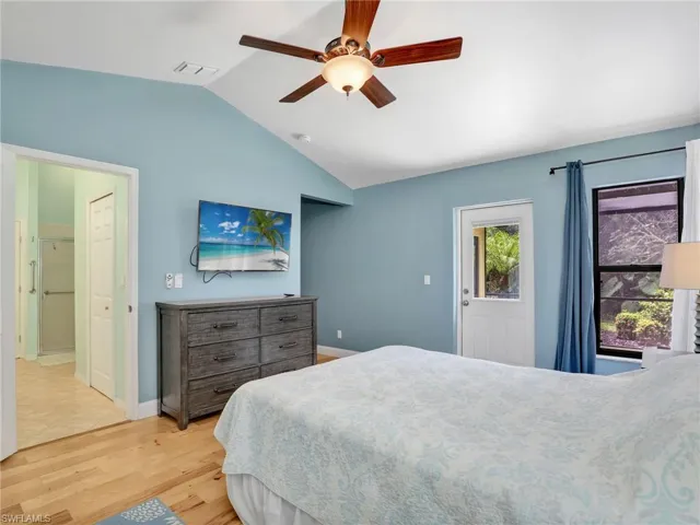 Bedroom featuring baseboards, ceiling fan, light wood-style flooring, and lofted ceiling