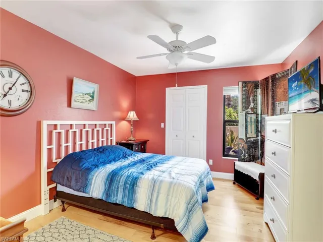 Bedroom with a ceiling fan, baseboards, light wood-style flooring, and a closet