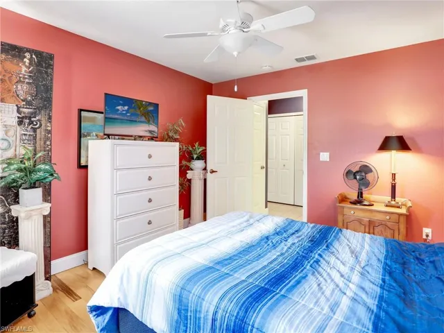 Bedroom featuring baseboards, a ceiling fan, light wood-style flooring, and visible vents