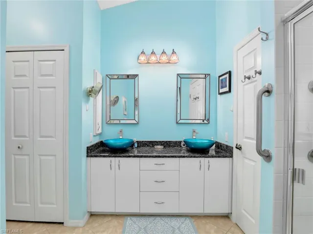 Full bathroom featuring a sink, a stall shower, and double vanity