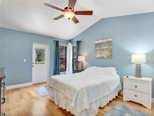 Bedroom featuring baseboards, a ceiling fan, light wood finished floors, and lofted ceiling